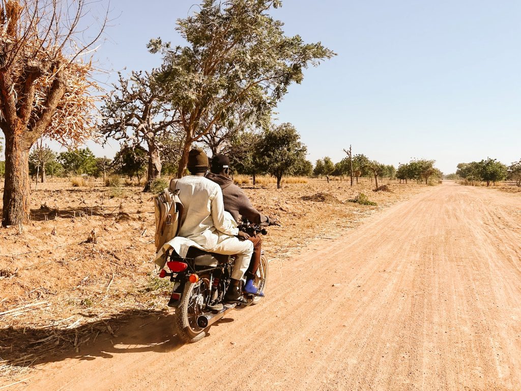 Two people ride a motorcycle in Kano State, Nigeria.