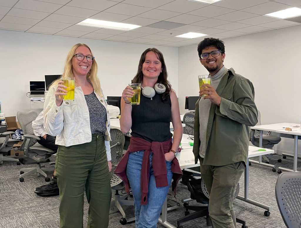 Photo of GiveWell staff members Erin, Katie, and Karthik holding glasses of oral rehydration solution.