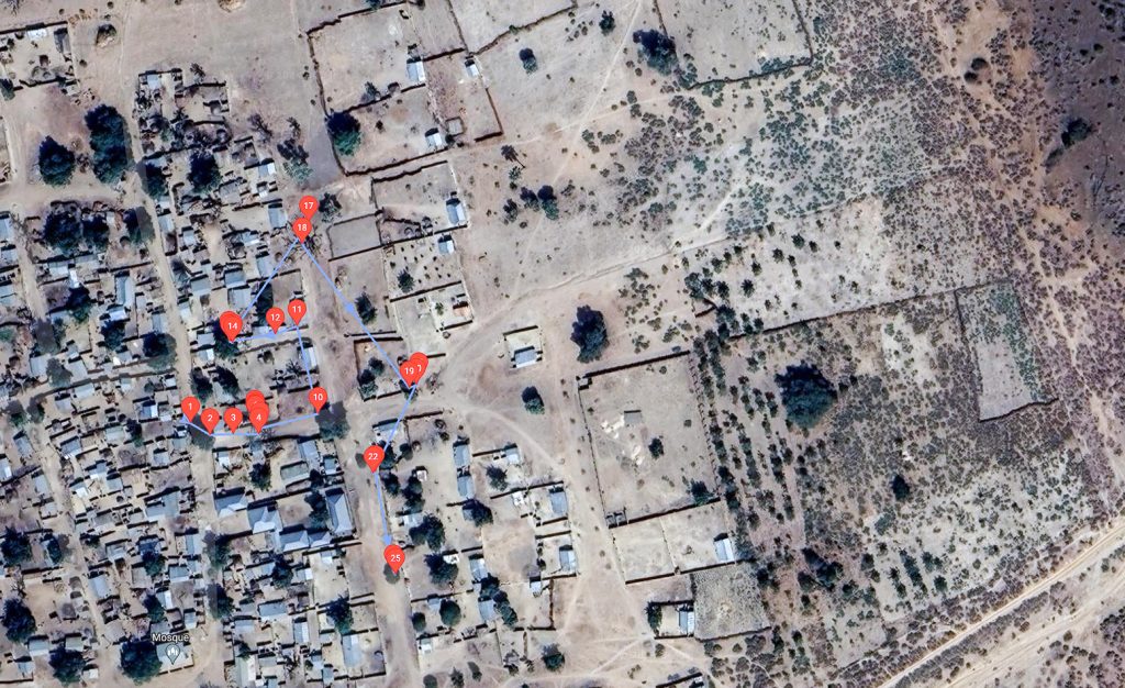 Satellite image of village, with some houses marked with numbers.